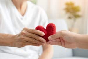 Young,And,Senior,Woman,Holding,Each,Other,Hands,And,Red